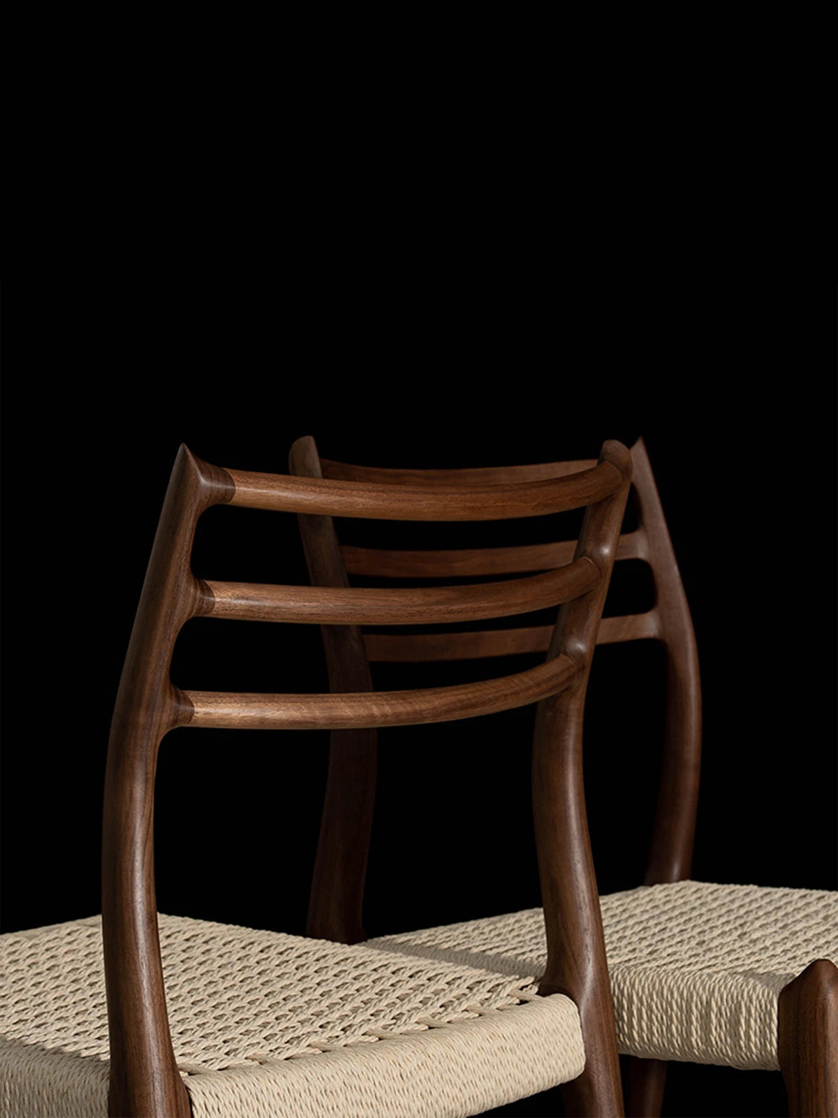 Detailed rear view showcasing the smooth woodworking and seamless joinery on the back of The Haven Dining Chair, made entirely of solid North American Black Walnut.