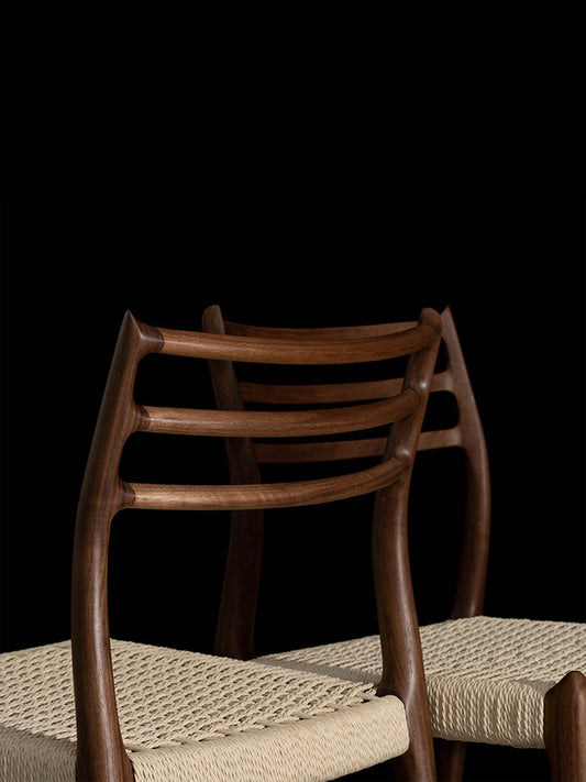 Detailed rear view showcasing the smooth woodworking and seamless joinery on the back of The Haven Dining Chair, made entirely of solid North American Black Walnut.