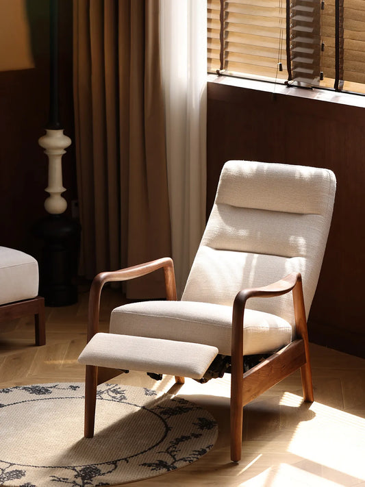 The Haven Lounge Chair by Walnutry shown in a reclined position with the footrest extended, sitting in a warm, sunlit room.