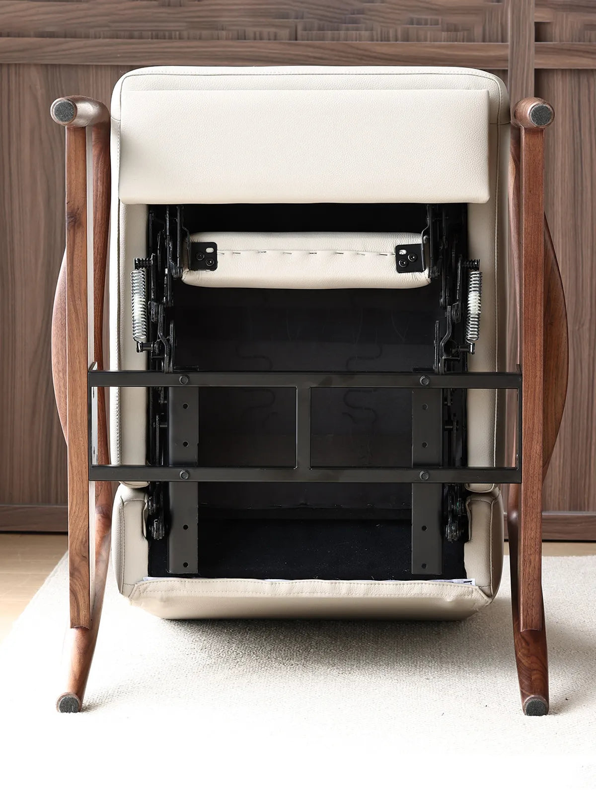 Bottom view of The Haven Lounge Chair by Walnutry, showing the durable steel reclining mechanism and solid black walnut frame.