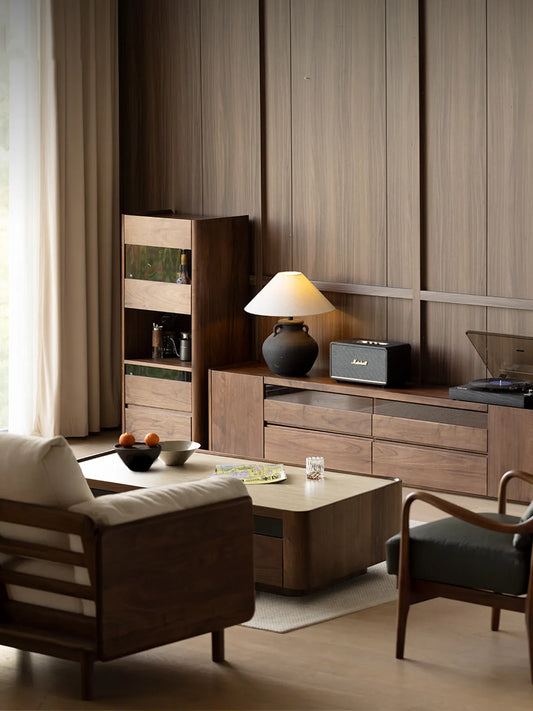 A fully furnished, elegant living room showcasing The Pebble Media Console alongside a matching tall display cabinet, coffee table, and lounge chairs.