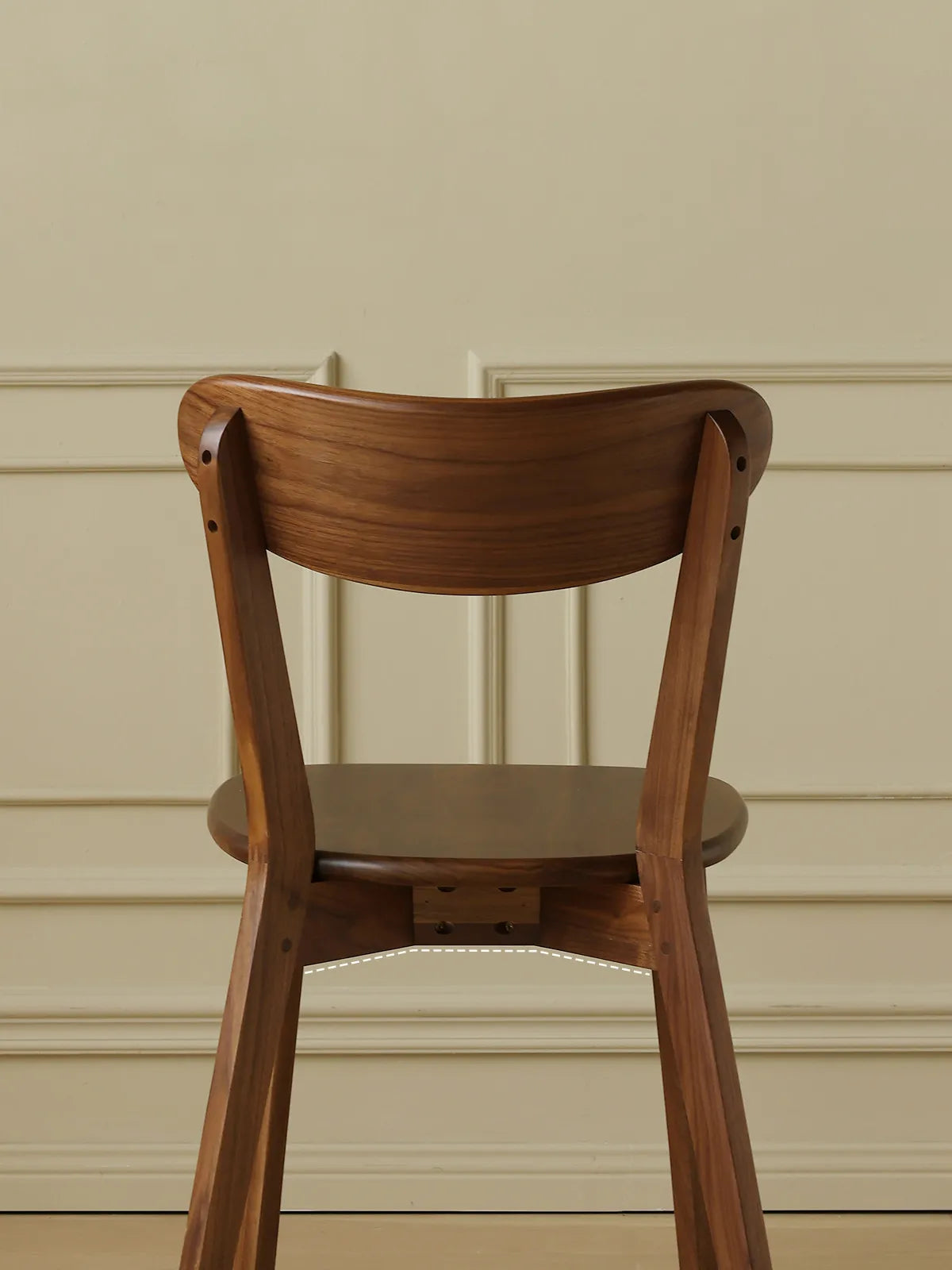 Detailed back view of The Sylva Dining Chair, showcasing the premium craftsmanship and natural grain patterns of the solid Black Walnut wood.