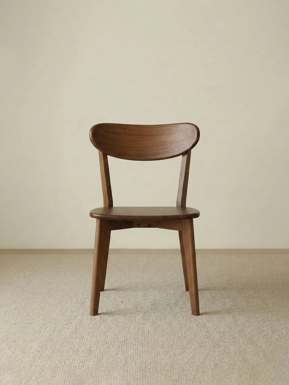 Clean front view of the minimalist The Sylva Dining Chair, built entirely from premium solid North American Black Walnut, displayed against a neutral background.