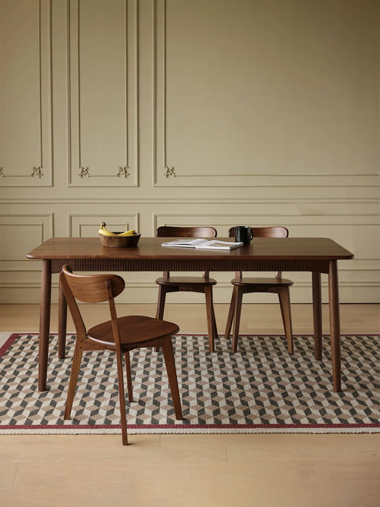 The Sylva Dining Chair styled in a warm home environment, perfectly complementing a solid North American Black Walnut dining table.