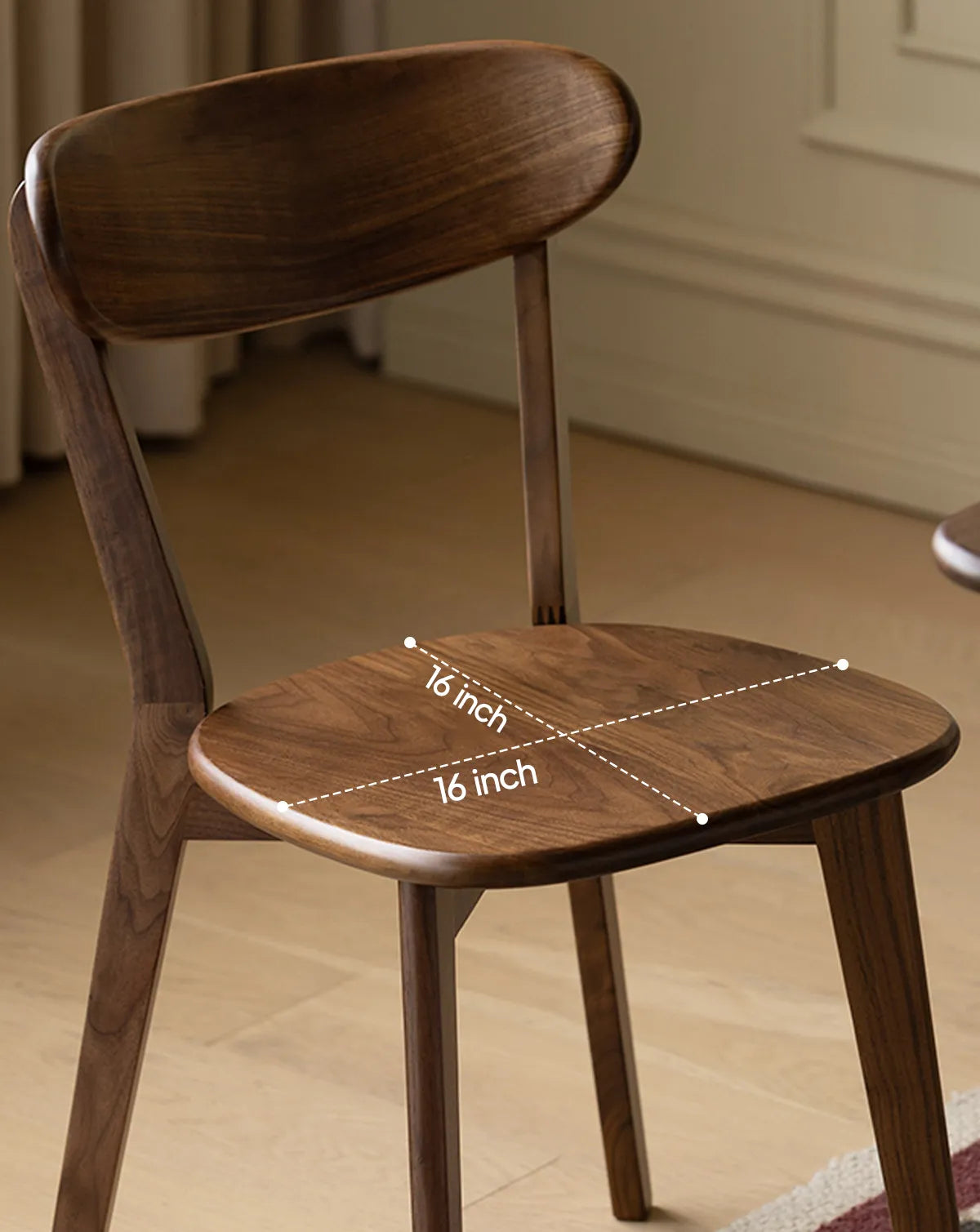 Close-up of the contoured 16 by 16 inch solid Black Walnut seat on The Sylva Dining Chair, highlighting the smooth finish and rich wood grain.