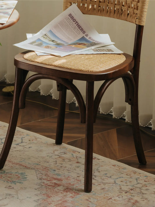 Front view of the Vilen chair showing curved bentwood-style legs and rattan seat from a low angle