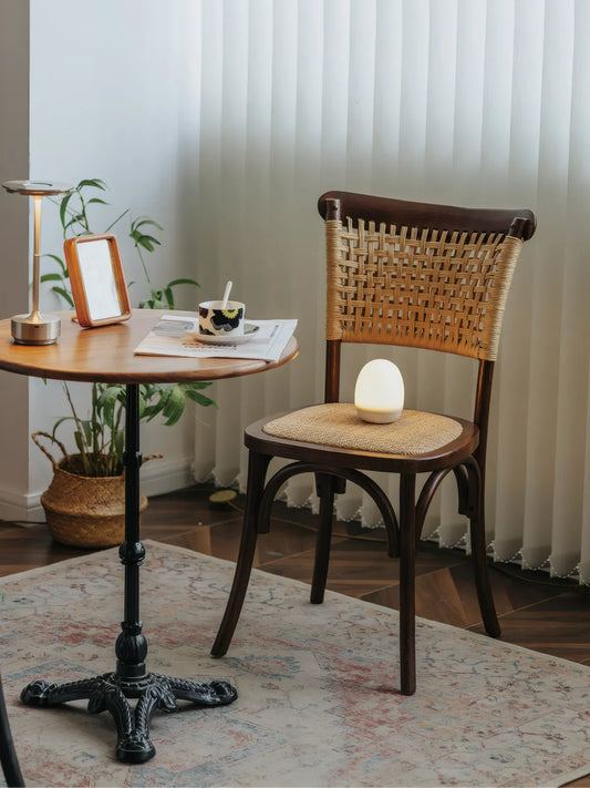 Vilen walnut dining chair styled beside a round bistro table in a bright living space