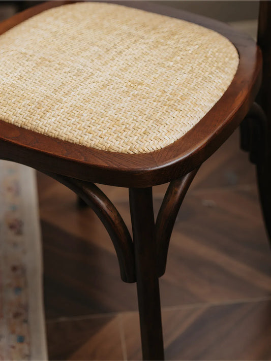 Overhead angle showing the woven rattan seat surface and curved walnut legs of the Vilen chair