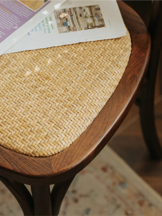 Close-up of the herringbone rattan woven seat and walnut seat frame on the Vilen dining chair