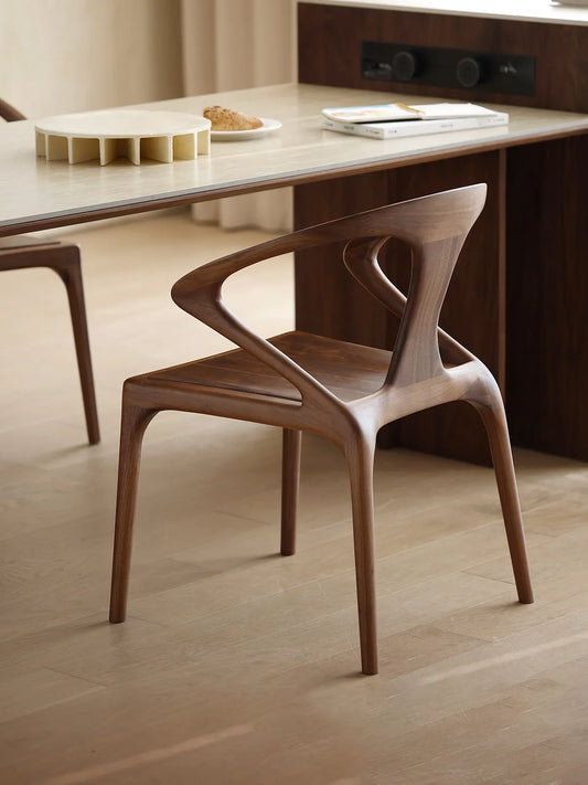 Rear angle of our walnut dining room chairs, displaying the unique, floating backrest design and smooth mortise joinery.