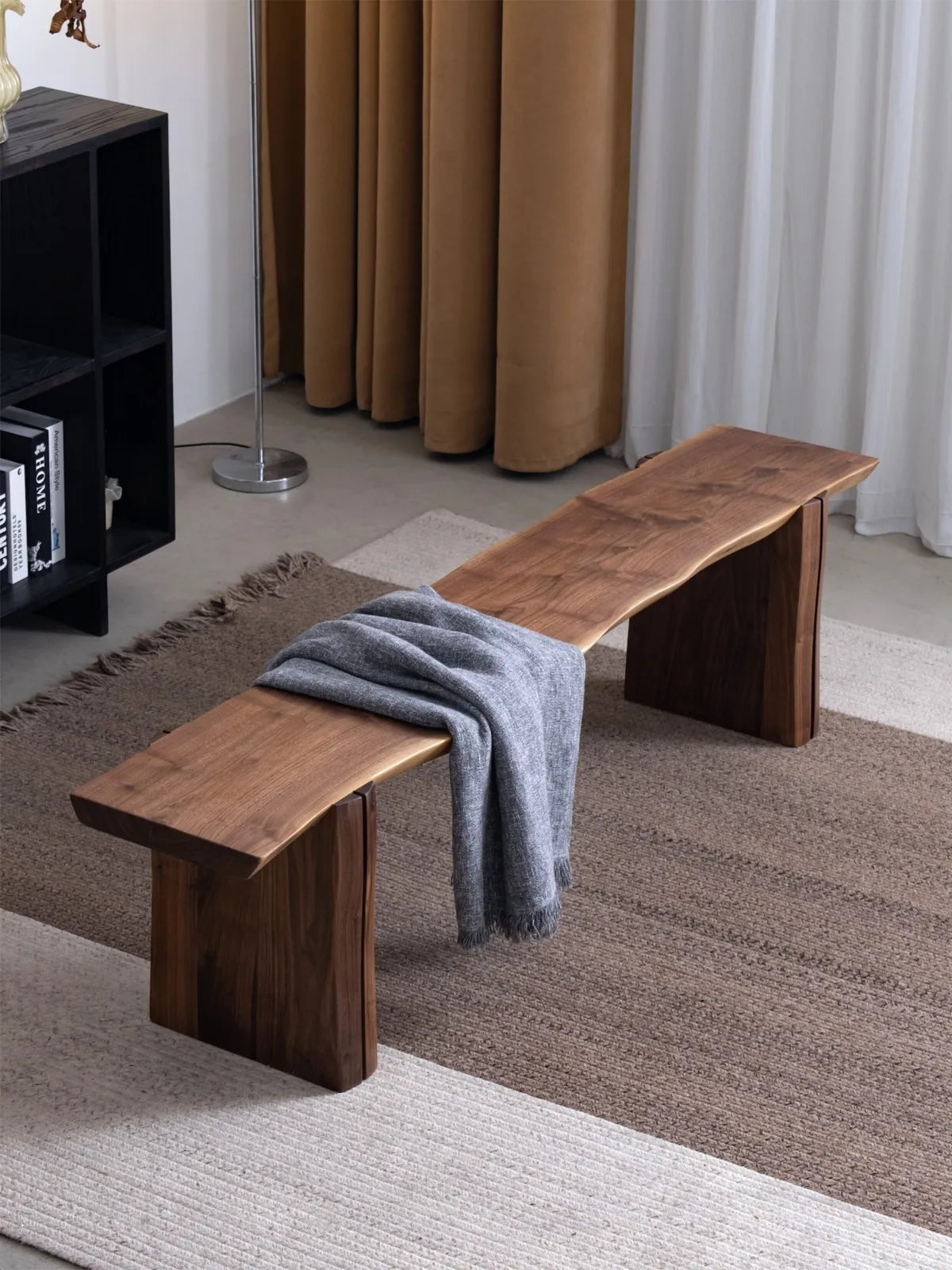 Walnutry Wilder live edge bench styled with a throw blanket in a warm interior, emphasizing its elongated seat and calm architectural presence.