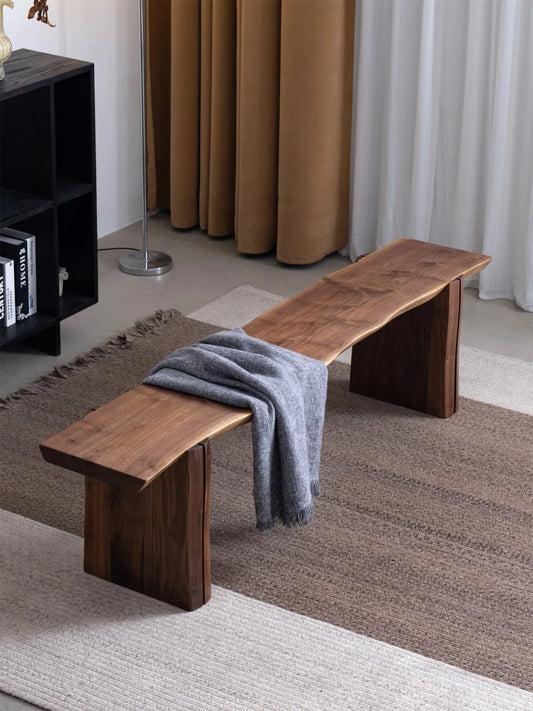 Walnutry Wilder live edge bench styled with a throw blanket in a warm interior, emphasizing its elongated seat and calm architectural presence.