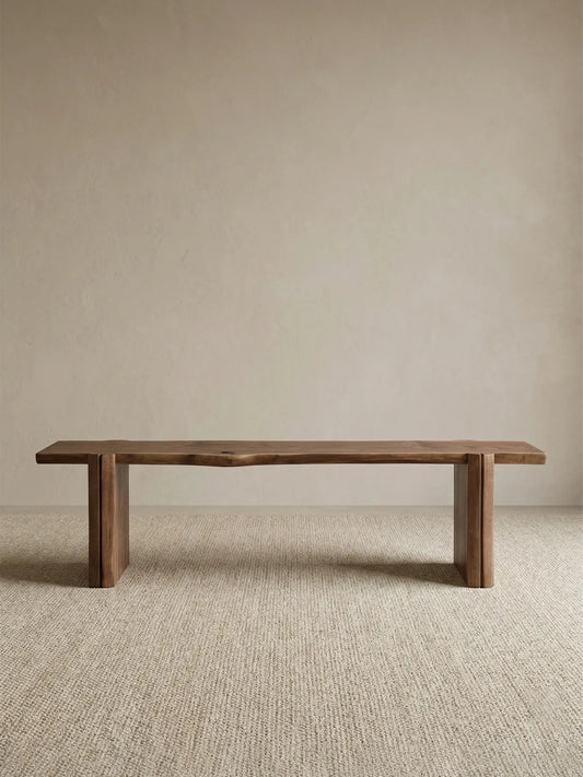 Walnutry Wilder organic wood bench shown in a full-room styled view, demonstrating its flexible use as a sculptural seating piece in a warm modern home.