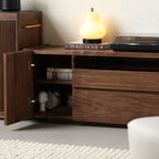 Open drawers of the walnut entertainment unit revealing ample storage space for media accessories and remotes.