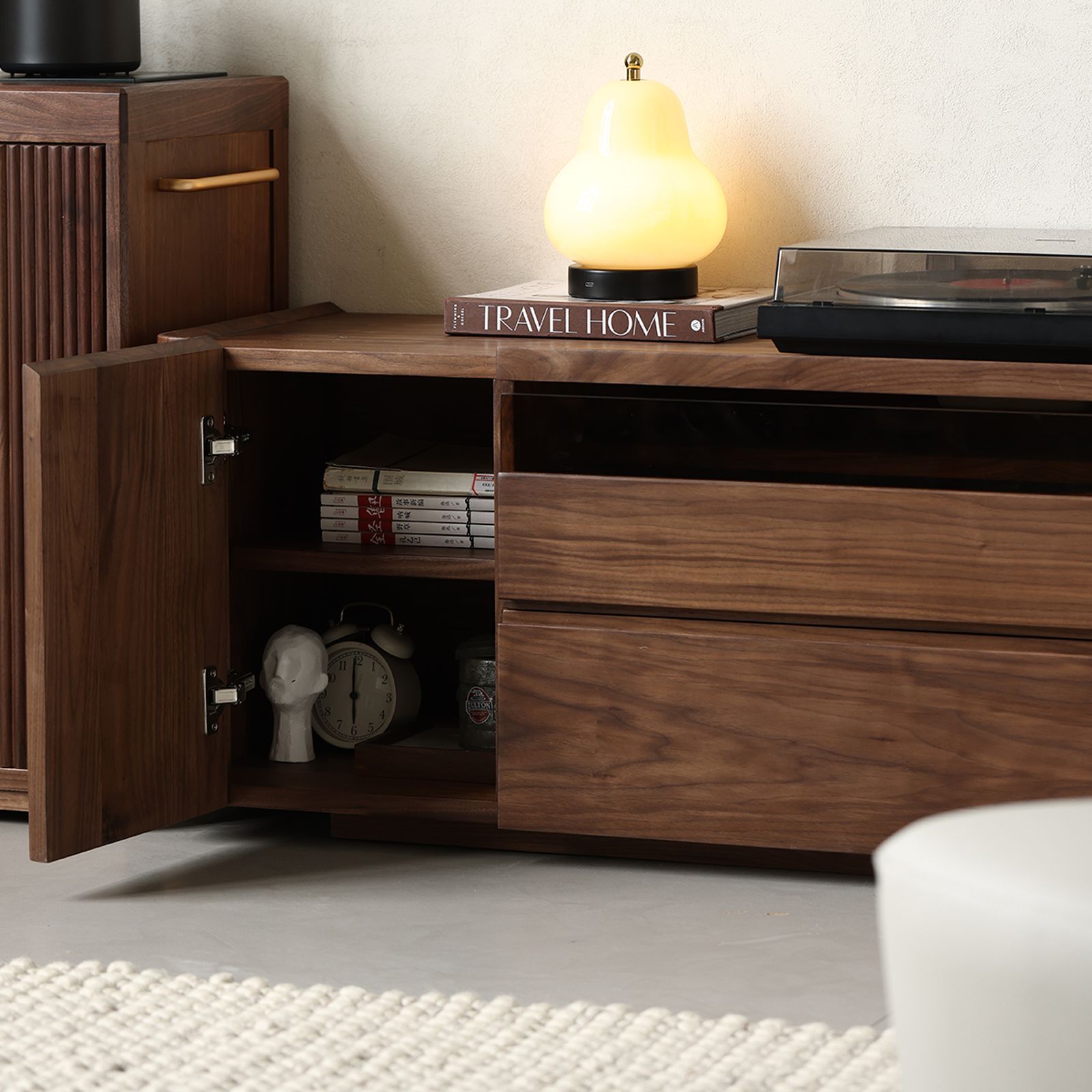 Open drawers of the walnut entertainment unit revealing ample storage space for media accessories and remotes.